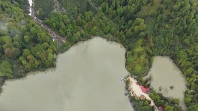 Görenler Gözlerine İnanamıyor: Aynı Anda Hem Kışı Hem Yazı Yaşatan Gizli Cennet! Artvin'deki Borçka Karagöl Tabiat Parkı, yüksek dağ zirvelerini kaplayan bembeyaz